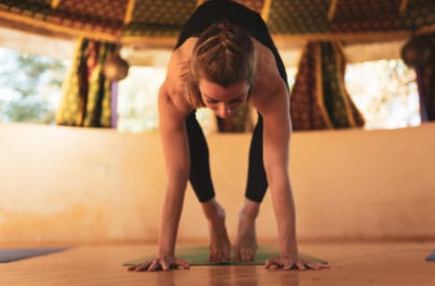 Pratiquante de yoga en appui sur les mains dans une formation avec ĀYU YOGA SCHOOL