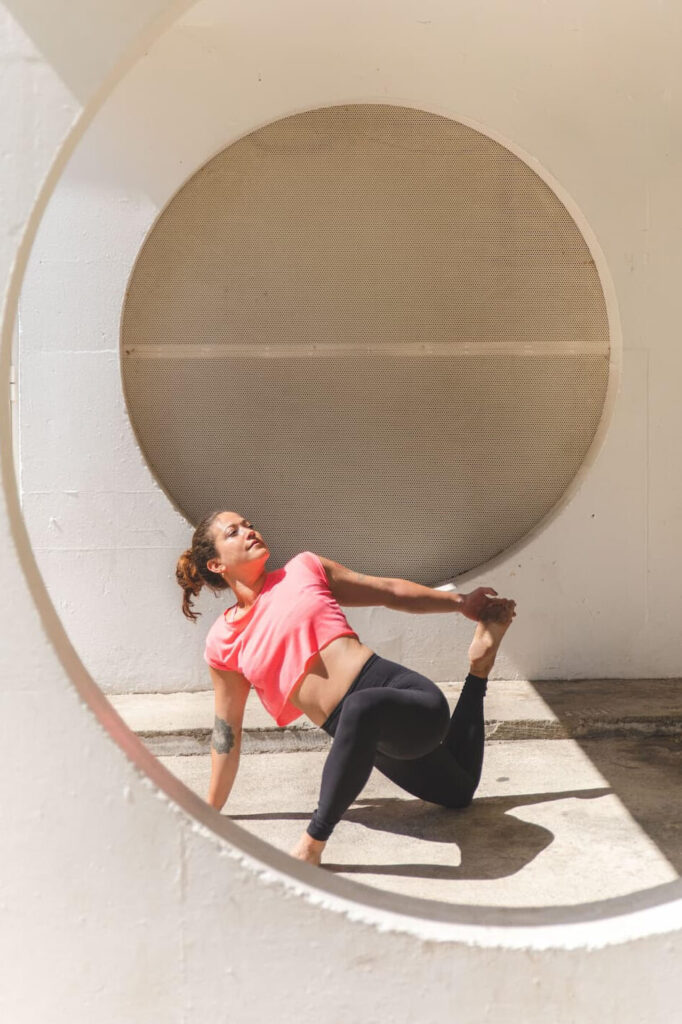 Carole Armoët, formatrice de yin yoga ĀYU YOGA SCHOOL, en train de pratiquer le yoga dans un décor urbain