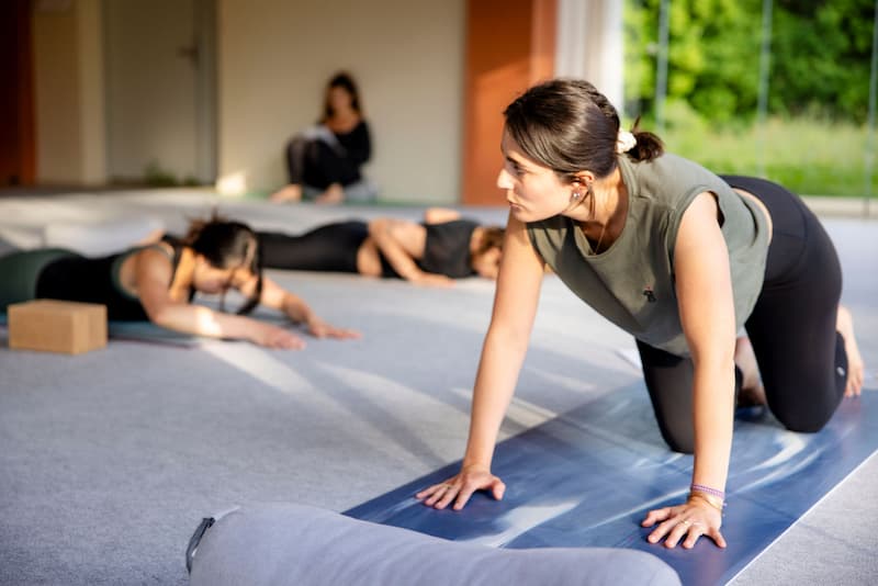 Élève s'entraînant à enseigner le yoga auprès de ses camarades de promo