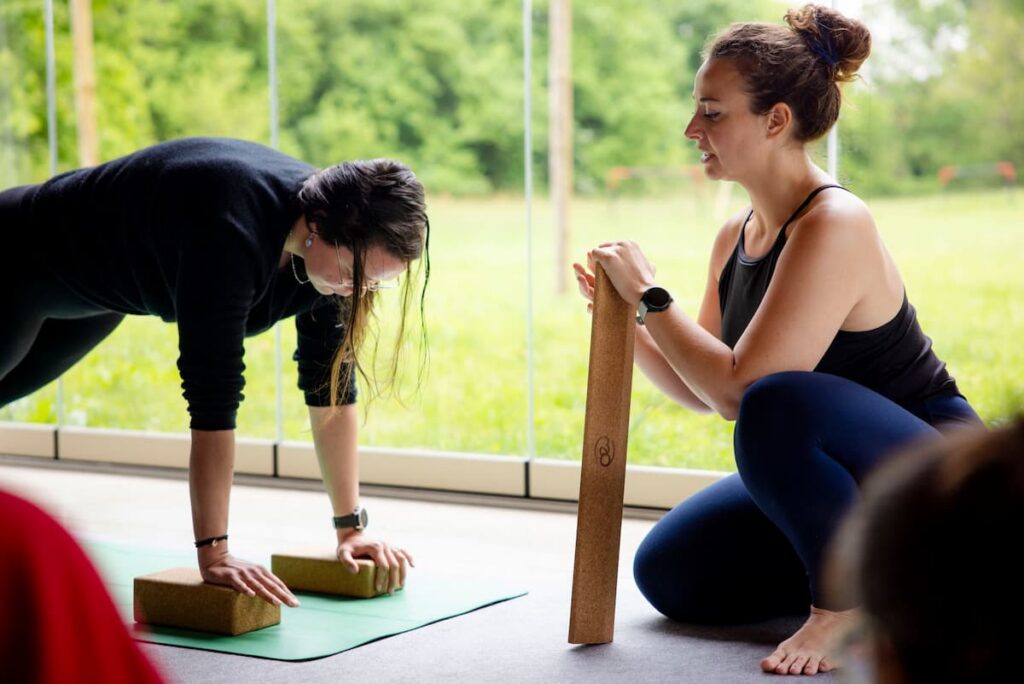 Manon faisant une démonstration d'utilisation des briques en yoga avec une élève